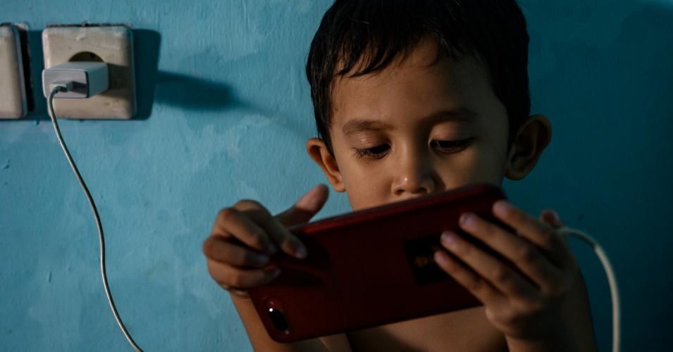 A child watches a video on a mobile phone at a house in Palu, Central Sulawesi Province, Indonesia on September 4, 2020. (Photo: Basri Marzuki/NurPhoto via Getty Images)