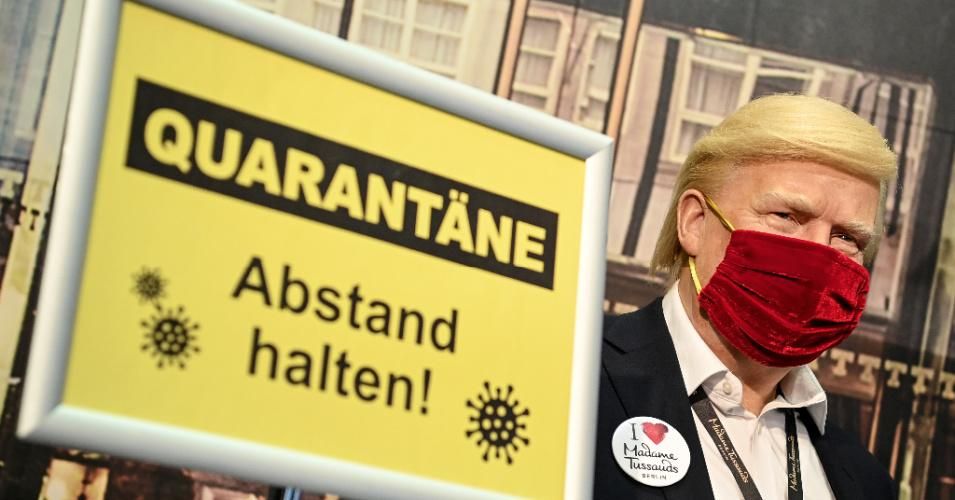 The wax figure of U.S. President Donald Trump stands behind a barrier and signs saying "Keep a distance from quarantine" at Madame Tussauds Berlin. (Photo: Britta Pedersen/picture alliance via Getty Images)