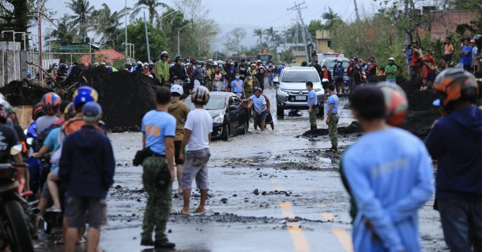 Residents gather along road damaged by heavy rains brought by the super Typhoon Goni after it hit the town of Malinao, Albay province, south of Manila on November 1, 2020. (Photo: Charism Sayat/AFP via Getty Images)