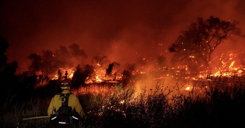 A firefighter surveys the Bond Fire—started by a structure fire that extended into nearby vegetation—on December 3, 2020 in Silverado, California. (Photo: Kent Nishimura/Los Angeles Times via Getty Images)