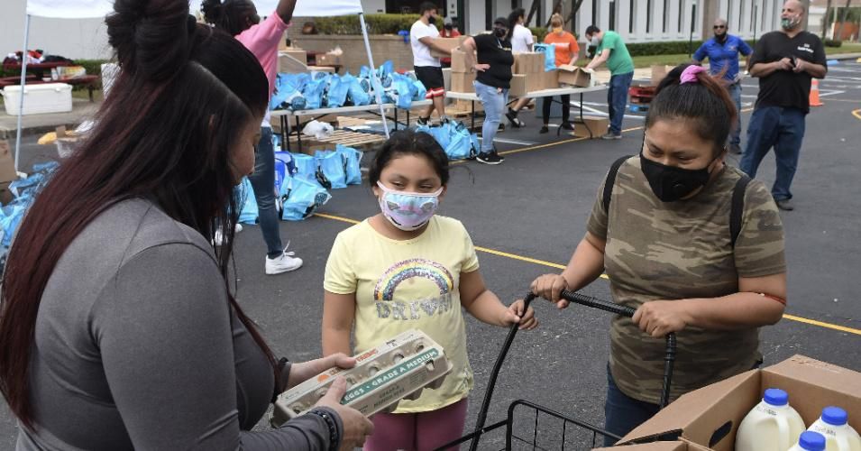 A woman and her daughter receive food assistance for laid off Walt Disney World cast members and others at a food distribution event on December 12, 2020 in Orlando, Florida. (Photo: Paul Hennessy/NurPhoto via Getty Images)