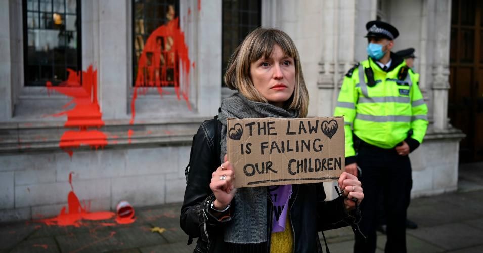 A police officer stands by as a campaigner against a third runway at Heathrow Airport holds a placard in front of paint thrown by another protester at the Supreme Court in London on December 16, 2020 after the verdict on a legal challenge to the proposed runway. (Photo: Daniel Leal-Olivas/AFP via Getty Images)