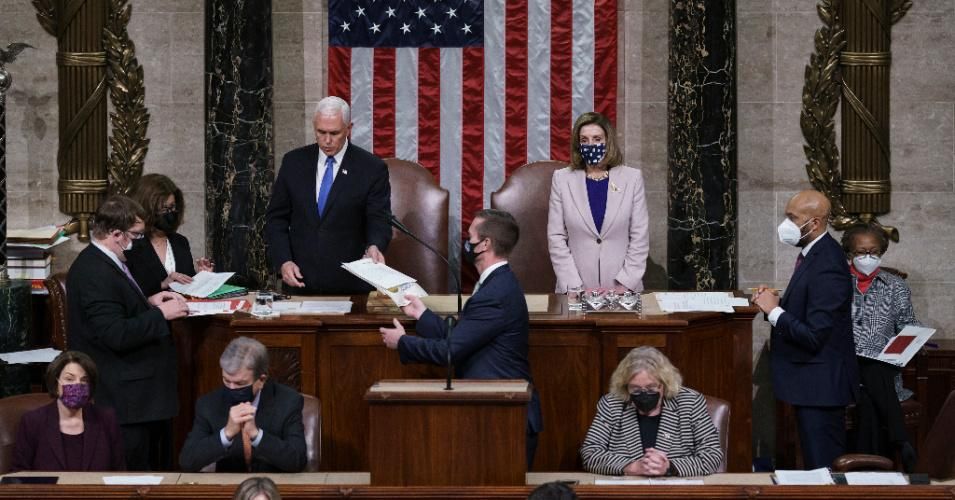Vice President Mike Pence hands the West Virginia certification to staff as Speaker of the House Nancy Pelosi (D-Calif.) listen during a joint session of Congress after working through the night, at the Capitol on January 7, 2021 in Washington, D.C.