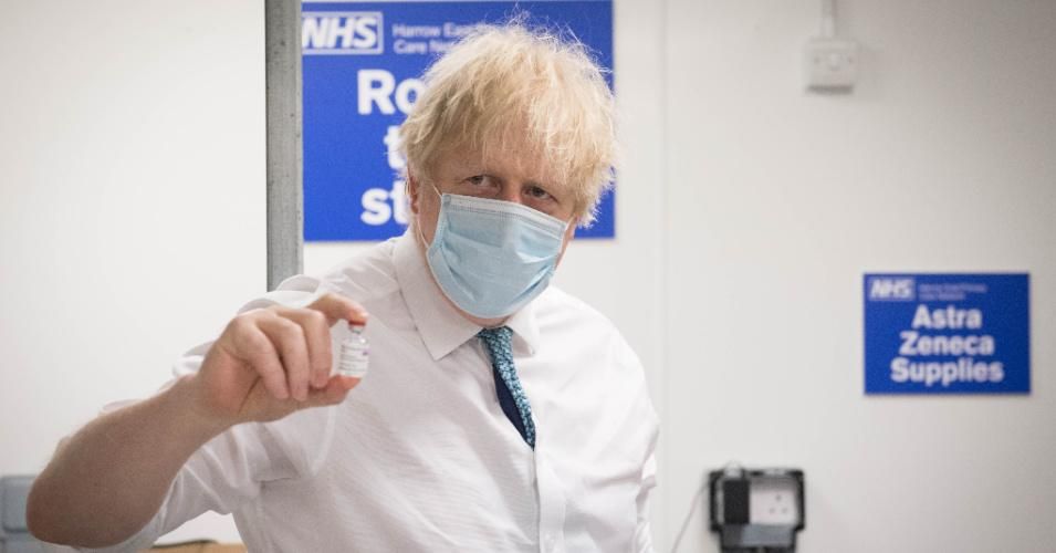 British Prime Minister Boris Johnson sees how a dose of the Oxford/Astra Zeneca Covid 19 vaccine is prepared for a mobile vaccination center on January 25, 2021 in London.