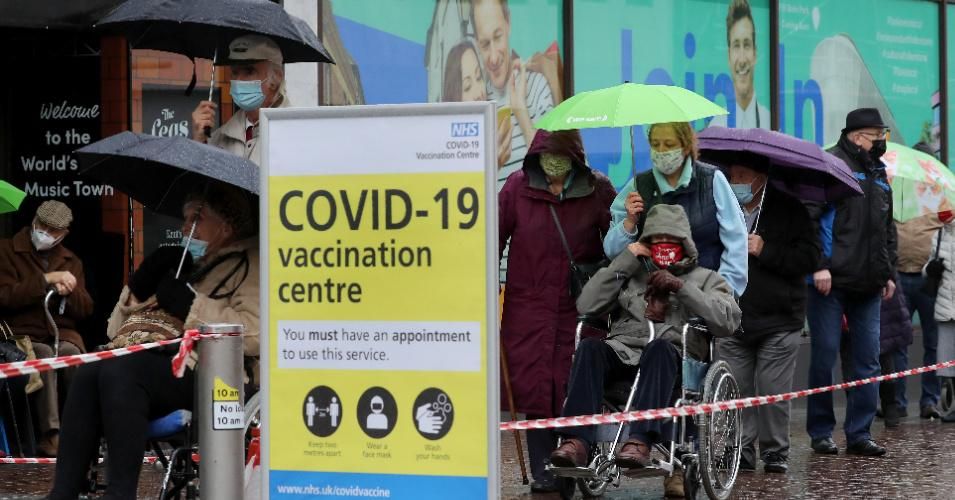 People queue in bad weather to enter a Covid-19 vaccination centre in Folkestone, Kent, during England's third national lockdown to curb the spread of coronavirus on Friday January 29, 2021.