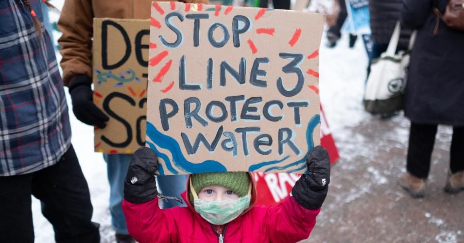 A young protester holds a sign reading "Protect Water" during a Line 3 pipeline protest in downtown St. Paul, Minnesota on January 29, 2021.