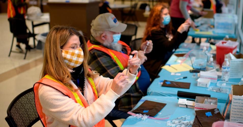 Volunteers and healthcare workers prepare Covid-19 vaccine doses at a vaccination hub location in League City, Texas on February 5, 2021.