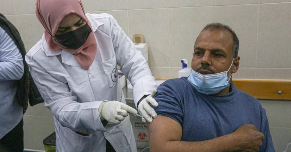 A Palestinian health worker gives a dose of the Russian Sputnik coronavirus vaccine in Khan Yunis, south of the Gaza Strip on February 24, 2021.