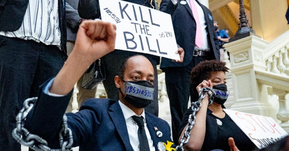 Demonstrators wear chains while holding a sit-in inside the Capitol building in opposition of House Bill 531 on March 8, 2021 in Atlanta, Georgia.