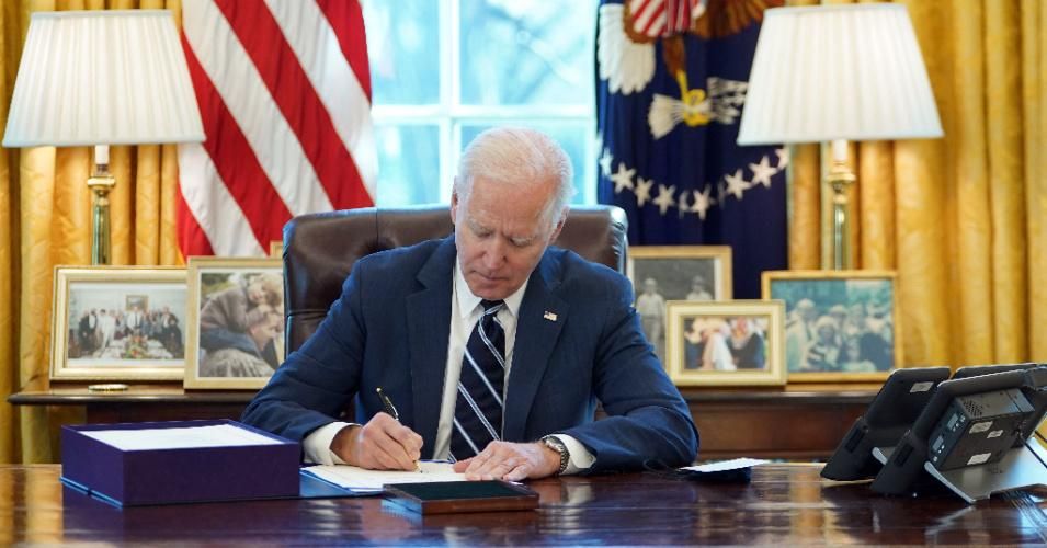 President Joe Biden signs the American Rescue Plan on March 11, 2021 in the Oval Office of the White House.