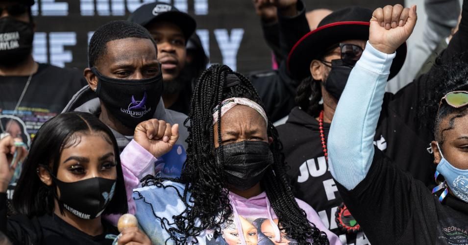 Tamika Palmer, mother of Breonna Taylor, and others stand with their fists up during a memorial protest in Jefferson Square Park on March 13, 2021 in Louisville, Kentucky.