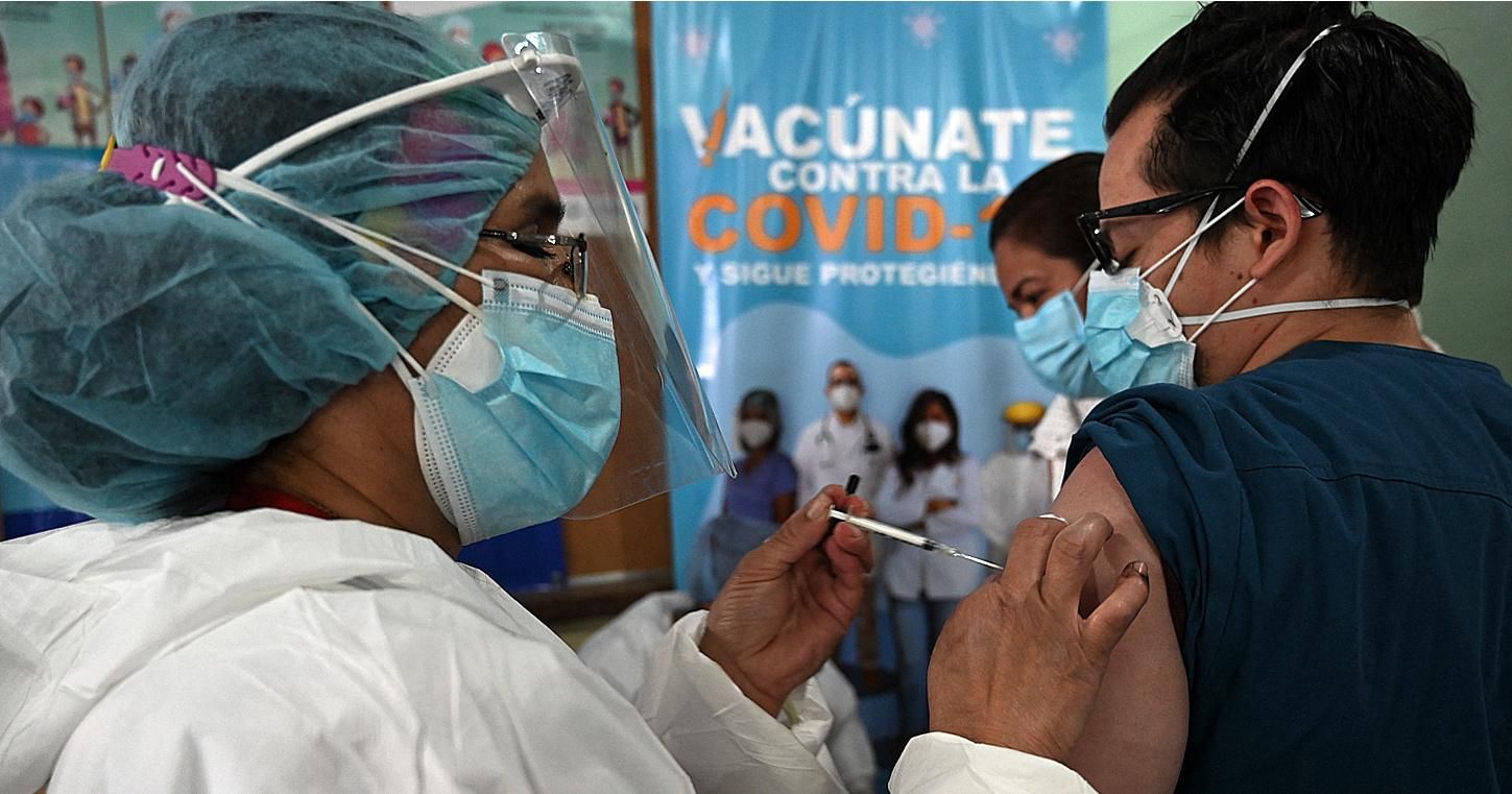 A nurse inoculates a man with an AstraZeneca vaccine against Covid-19 at the Alonso Suazo healthcare center in Tegucigalpa, Honduras on March 15, 2021, as over 48,000 doses donated by COVAX started to be administered to employees of the country's Health Secretariat. (Photo: Orlando Sierra/AFP via Getty Images)