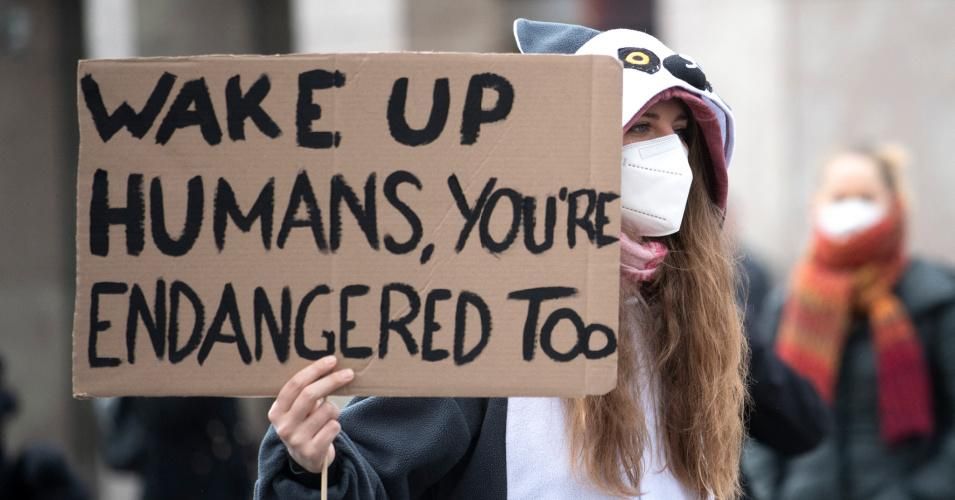 A woman holds a poster reading, "Wake up humans, you're endangered too," at a Fridays for Future protest for climate action in Vienna, Austria on March 19, 2021. (Photo: Joe Klamar/AFP via Getty Images)