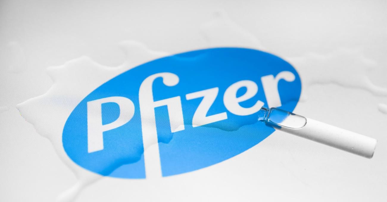 The Pfizer logo is photographed with a vial and spilled liquid for an illustration photo. (Photo: Beata Zawrzel/NurPhoto via Getty Images)
