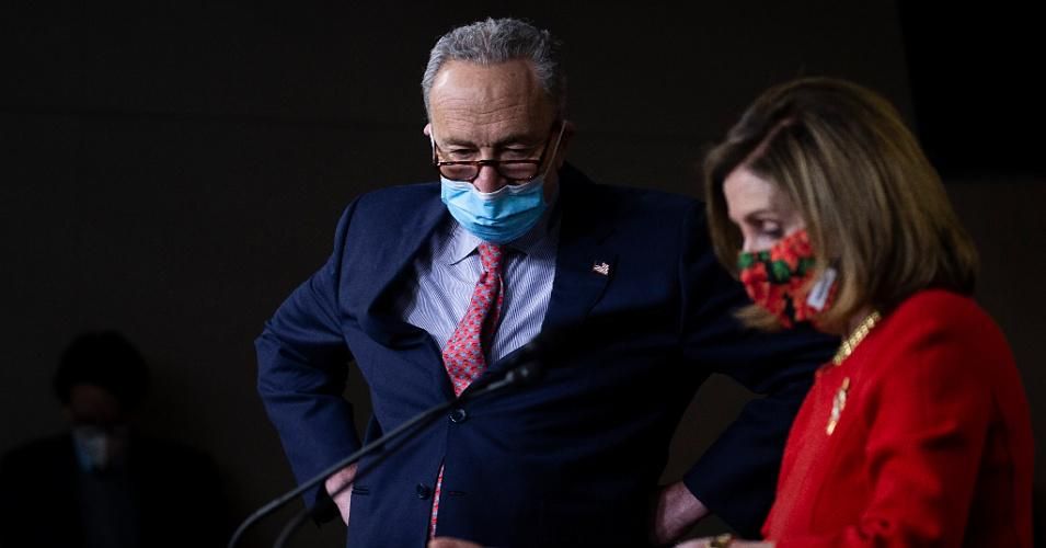 Senate Majority Leader Chuck Schumer (D-N.Y.) listens as House Speaker Nancy Pelosi (D-Calif.) speaks during a press conference on Capitol Hill in Washington, D.C.