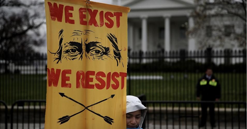 A protester holds a sign in front of the White House during a demonstration against the Dakota Access Pipeline on March 10, 2017 in Washington, D.C. (Photo: Justin Sullivan/Getty Images)