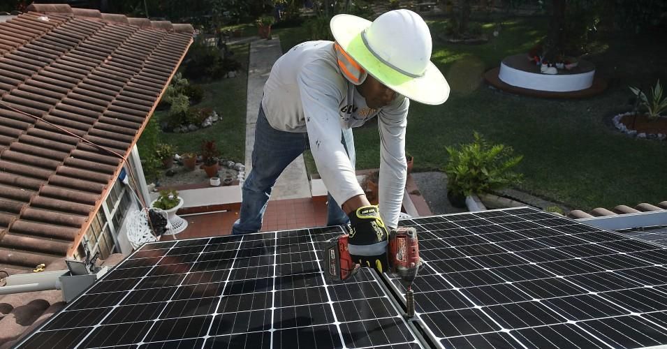 Roger Garbey, from the Goldin Solar company, installs a solar panel system on the roof of a home a day after the Trump administration announced it will impose duties of as much as 30% on solar equipment made abroad on January 23, 2018 in Palmetto Bay, Florida. (Photo: Joe Raedle/Getty Images)