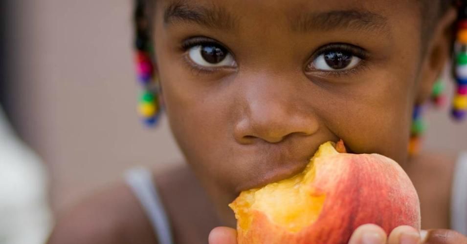 child eats fruit