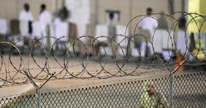 Detainees are seen through barbed wire at Guantánamo Bay military prison. 