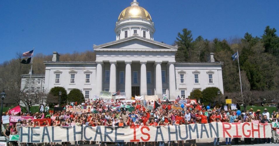 Nearly four years ago, Vermont became the first U.S. state to pass a law for universal, publicly-funded health care. This photograph depicts a 2011 rally at the Vermont Capitol. (Photo: Vermont Workers' Center)</p>