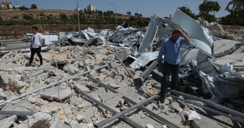 Palestinians inspect the debris of a quarantine center established to fight the coronavirus pandemic after Israeli soldiers demolished the single-story center in Hebron, West Bank on July 21, 2020.