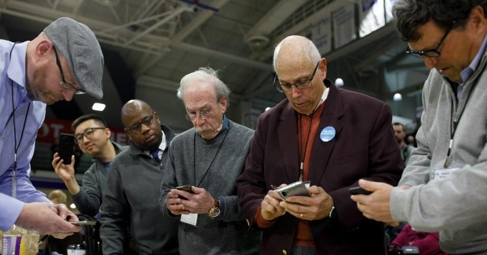 Officials from the 68th caucus precinct overlook the results of the first referendum count during a caucus event on February 3, 2020 at Drake University in Des Moines, Iowa.