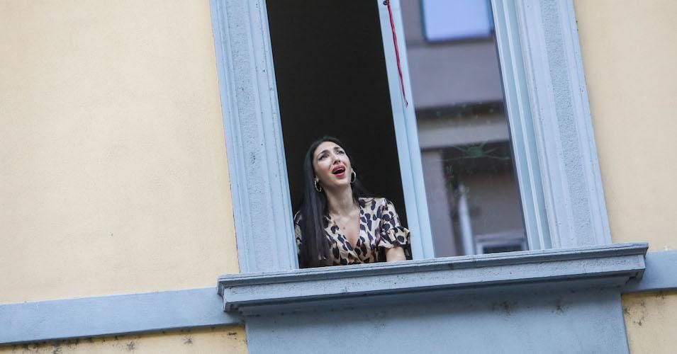 A young woman sings from the window in Italy, March 13, 2020. Some people in the country asked the public to stand on the balcony and sing or play something, to make people feel united in the quarantine.