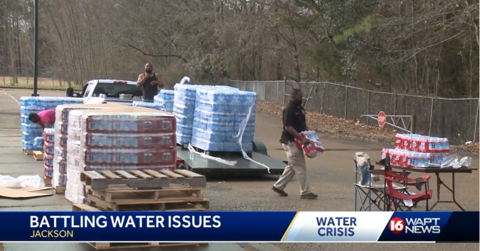 City Council President Aaron Banks carries bottled water at a local distribution center in Jackson, Mississippi. (Photo: Screengrab from ABC 16 WAPT News)
