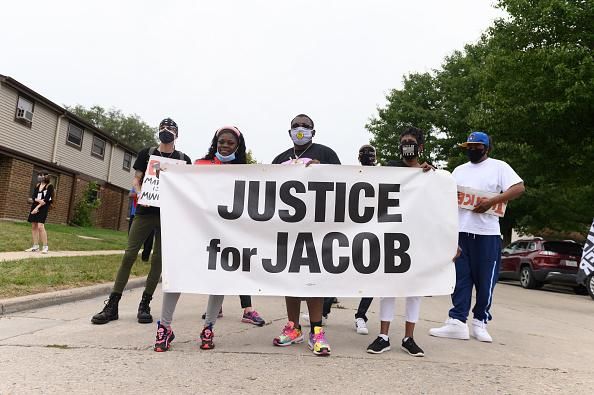 Protesters held a banner during a community celebration and call for justice for Jacob Blake that took place while Donald Trump visited Kenosha, Wisconsin on September 1, 2020. (Photo: Daniel Boczarski/Getty Images for MoveOn)
