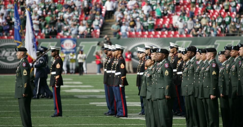 Marine Corps, Air Force, Navy, Coast Guard and Army service members salute during a ceremony at Giants stadium before the New York Jets game against the Jacksonville Jaguars. (Photo: Marine Corps/Sgt. Randall A. Clinton/public domain)