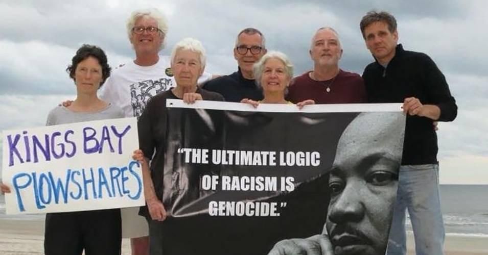 Kings Bay Plowshares 7 members pose for a photo with a banner showing peace activist Rev. Martin Luther King Jr. (Photo: Kings Bay Plowshares 7)