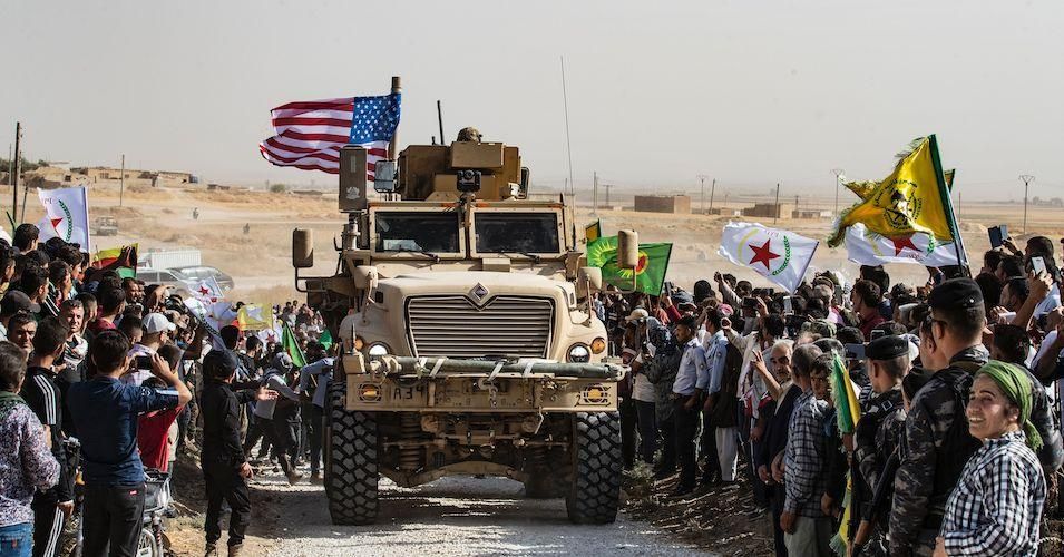 Syrian Kurds gather around a US armoured vehicle during a demonstration against Turkish threats next to a U.S.-led international coalition base on the outskirts of Ras al-Ain town in Syria's Hasakeh province near the Turkish border on October 6, 2019.