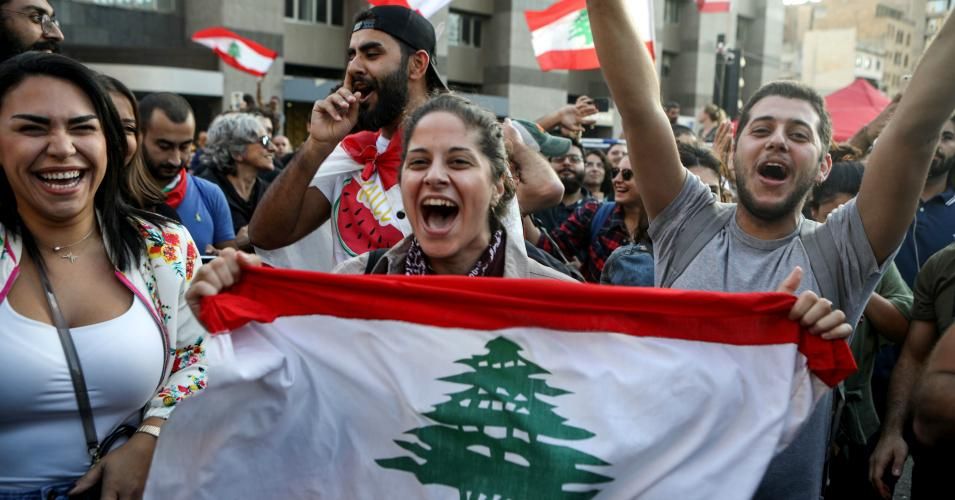 A Lebanese protester waves a national flag as he marches with others during a demonstration along the Fuad Chehab avenue in the capital Beirut on October 29, 2019 on the 13th day of anti-government protests.