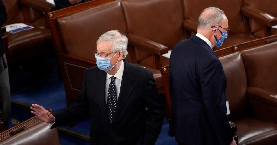 Senate Majority Leader Mitch McConnell (R-Ky.) and Senate Minority Leader Chuck Schumer (D-N.Y.) stand back to back in the House Chamber during a joint session of Congress on January 6, 2021 in Washington, D.C.