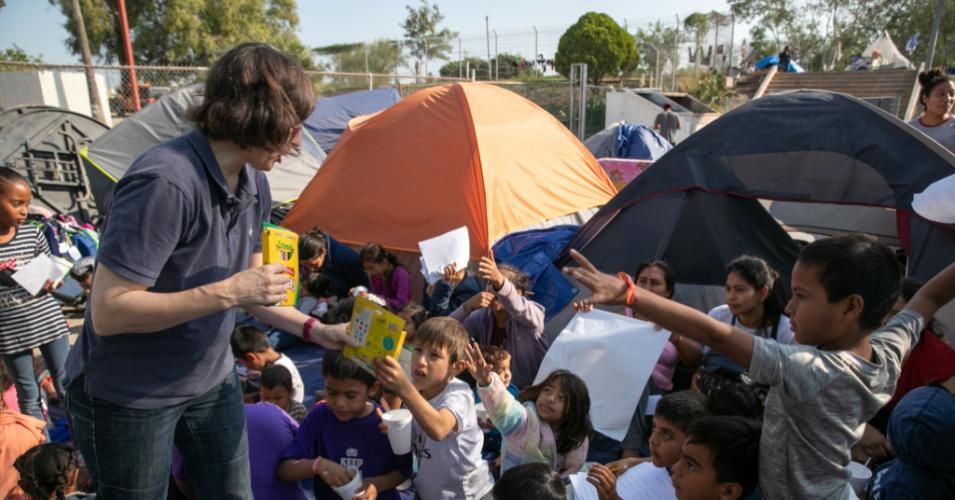 U.S. volunteer Mary Keenan of Brownsville, Texas hands out markers on December 8, 2019 during a class for immigrant children at a refugee camp near the Gateway International Bridge in the border town of Matamoros, Mexico, where more than 1,000 Central American and Mexican asylum-seekers are awaiting their next court hearings. (Photo: John Moore/Getty Images)