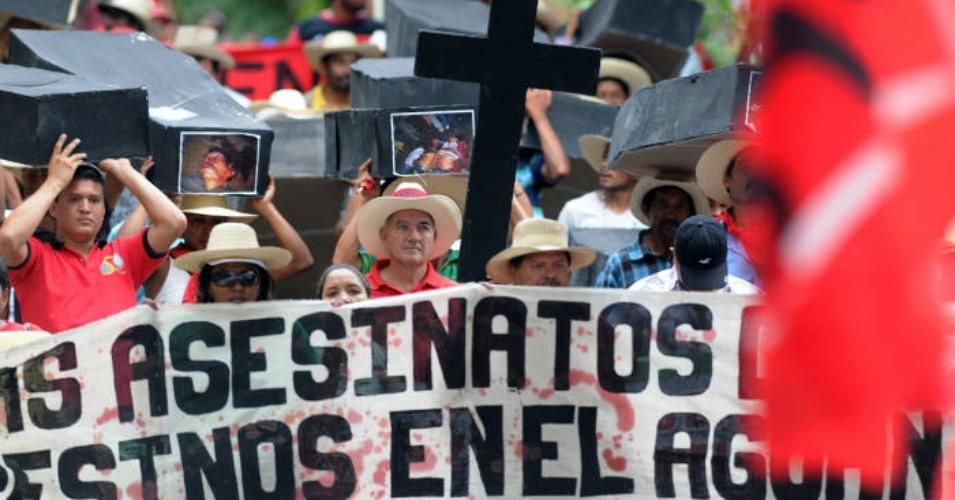 Members of the Unified Campesinos Movement of the Aguán Valley (MUCA) carry mock coffins bearing photos of murdered relatives during a 2012 march against the ongoing violence in the Baja Aguán valley.