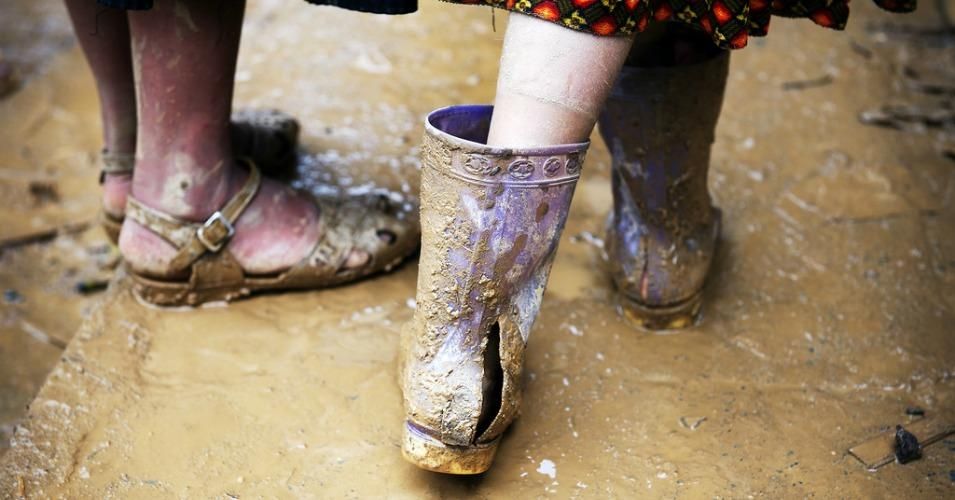 A teenager wears torn rubber boots in a muddy local market in Bac Ha, Viet Nam. (Photo: UN Photo/Kibae Park)