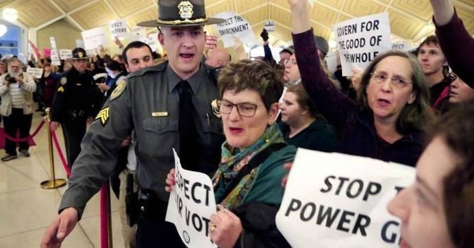 A General Assembly police officer moves protesters back as they hold signs and chant outside the N.C. House chambers Thursday. (Photo: Chris Seward/ News & Observer) Read more here: http://www.newsobserver.com/news/politics-government/state-politics/article121222618.html#storylink=cpy