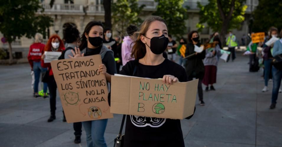 Activists hold signs reading "We Are Treating the Symptoms, Not the Cause" and "There Is No Planet B" during a climate justice demonstration outside the Spanish Parliament on September 25, 2020 in Madrid. (Photo: Pablo Blazquez Dominguez via Getty Images)