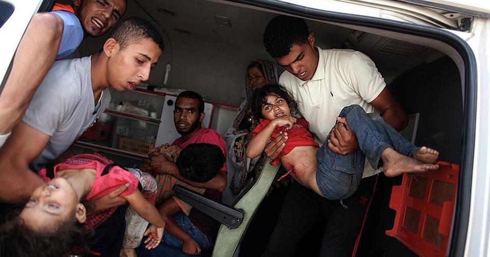  Palestinians carry injured people following an Israeli military strike on a UN school in Rafah, in the southern Gaza Strip on August 3, 2014. At least 10 people were killed in a fresh strike on a UN school in southern Gaza which was sheltering Palestinians displaced by an Israeli military offensive, medics said. (Photo by Ali Hassan/Anadolu Agency/Getty Images)