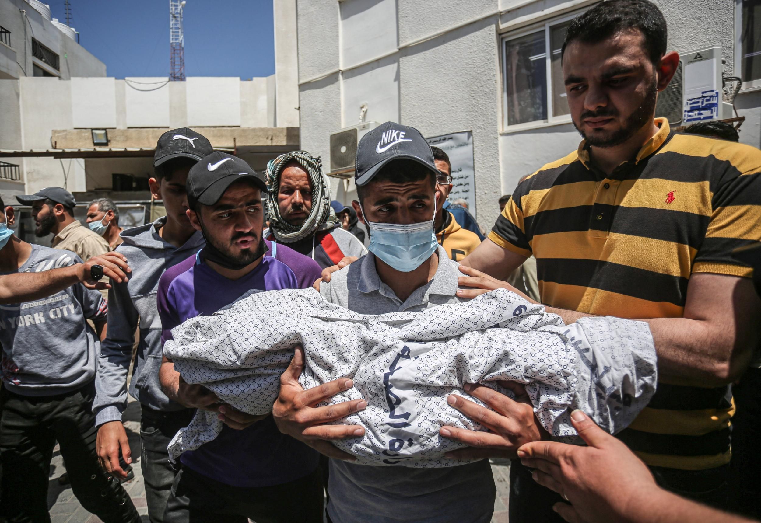 A Palestinian man carries the body of Ibrahim Al-Rantisi, a young child who was killed during an Israeli airstrike, before his burial in Rafah, located in the southern Gaza Strip. (Photo: Yousef Masoud/SOPA Images/LightRocket via Getty Images)