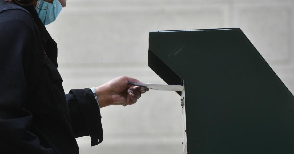 A woman deposits her ballot in an official ballot drop box at the satellite polling station outside Philadelphia City Hall on October 27, 2020 in Philadelphia, Pennsylvania.