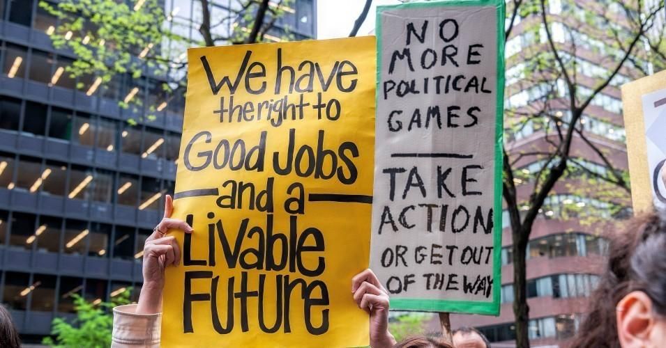 demonstrators hold signs demanding "a livable future"