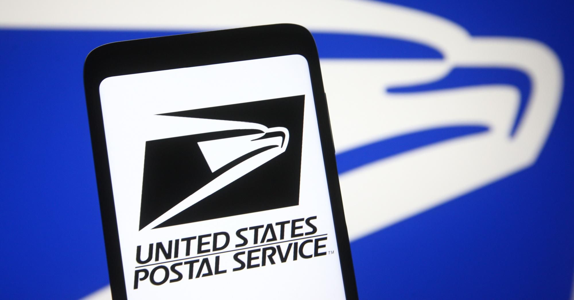In this photo illustration, the United States Postal Service (USPS) logo is seen on a smartphone and a PC screen.