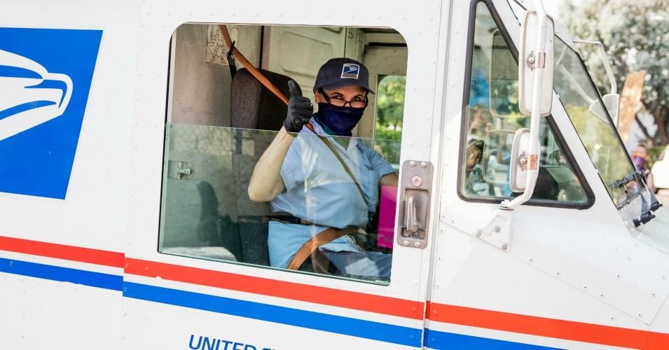 A postal worker gives a thumbs-up to demonstrators protesting the Trump administration's sabotage of the U.S. Postal Service on August 22, 2020 in Los Angeles, California.