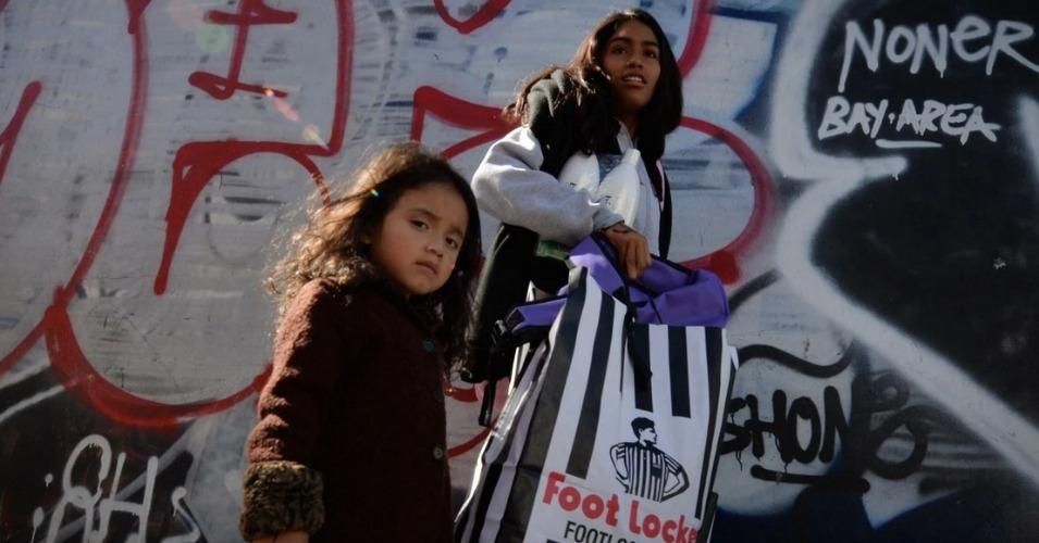 A three-year-old girl waits with her mother after receiving shoes and school supplies during a charity event in October to help more than 4,000 underprivileged children at the Fred Jordan Mission in the Skid Row area of Los Angeles (Photo: Mark Ralston/AFP/Getty Images)