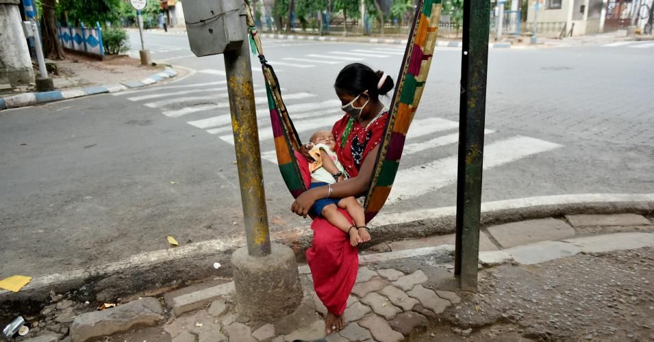 Momina, a 26 year-old homeless woman, carries her child on her lap while she swings on a makeshift cradle on the pavement during a government-imposed nationwide lockdown as a preventive measure against the Covid-19 pandemic in Kolkata, India on May 7, 2020. (Photo: Indranil Aditya/NurPhoto via Getty Images)