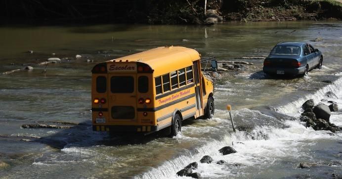 A school bus crosses a makeshift automobile bridge after the original bridge was washed away during Hurricane Maria flooding, on December 20, 2017 in Morovis, Puerto Rico. (Photo: Mario Tama/Getty Images)