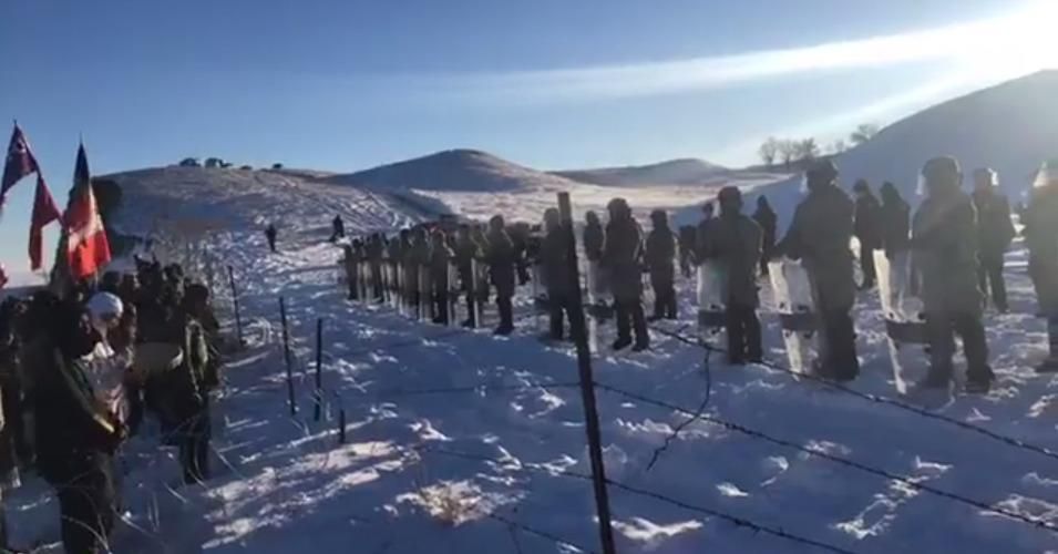Water protectors peacefully sang, drummed, and chanted as riot police blocked them from the pipeline drill site. 