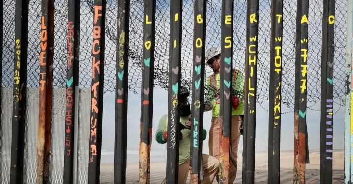 Workers on the American side of the border repair a hole in the border wall that separates the U.S. and Mexico where the wall meets the Pacific Ocean on January 28, 2019 in Tijuana, Mexico. 